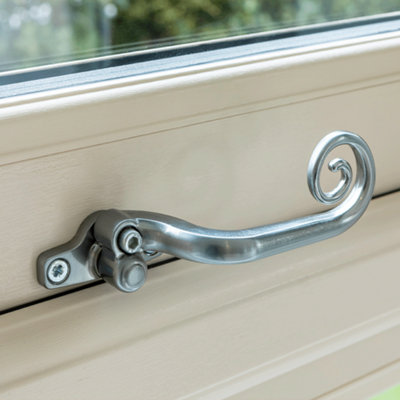 Traditional style steel locking mechanism and handle shown close up on white upvc window.
