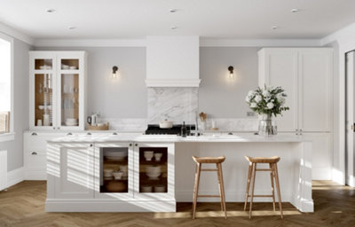 Porcelain white shaker kitchen with marble-effect worktops, central island, glazed cabinets and breakfast seating.
