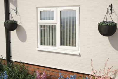 An exterior home wall with a double glazed window with white frames.