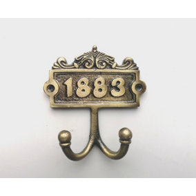 1883 ANTIQUE BRASS DOUBLE COAT HOOK WITH A PAIR OF MATCHING SCREWS - CAST IRON
