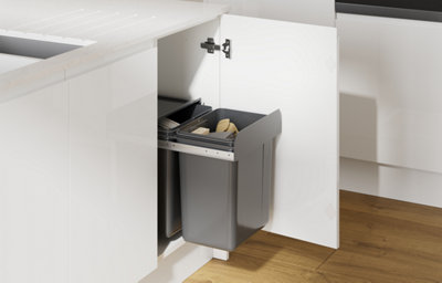 Gloss white slab kitchen with integrated handles, showing a pull-out bin system built into a base unit beneath a marble-effect worktop.