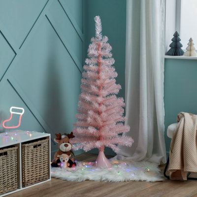 Small, artificial pink christmas tree in the corner of a children's playroom.