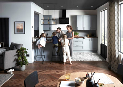 Open plan kitchen diner with light blue kitchen cabinets, dark wooden flooring and a family gathered around the kitchen island.