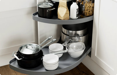 An open corner cupboard reveals a clever storage solution. As the cupboard opens, the shelving extends out into the kitchen, making it easy to reach pots and pans buried at the back of the deep cupboard.
