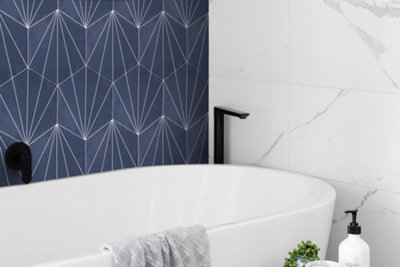 Blue tiles next to white marble tiles above bath.