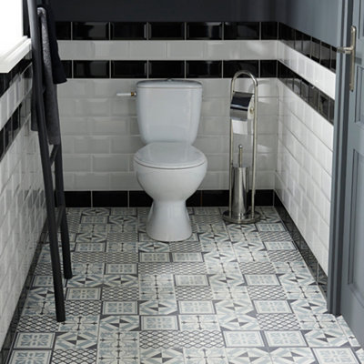 Navy blue and white self adhesive vinyl floor tiles with multiple different patterns installed in a cloakroom.