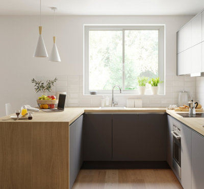 A grey and white kitchen with wooden worktops, with storage containers placed besides the sink.
