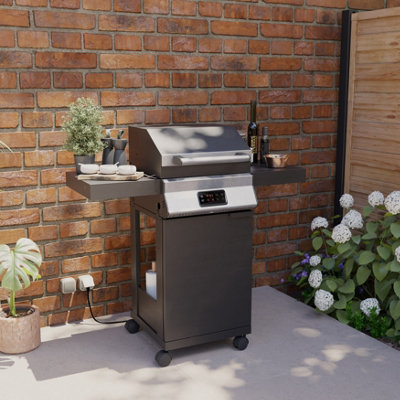 Large electric barbecue with lid closed sitting on a patio.