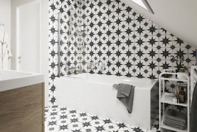 Matching black and white bathroom floor and wall tiles with a star pattern.