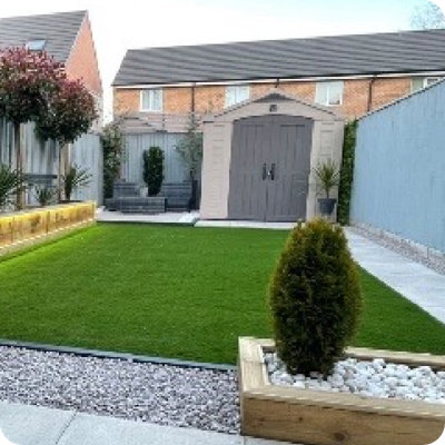 A compact, light blue and white garden shed is neatly placed in the corner of a modern patio with gray fencing and tiled flooring. The sky is partly cloudy above a row of neighboring houses. This user-generated image was shared from a real garden on Instagram with the handle @dg_homeinterior