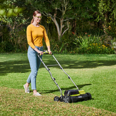 Lawn scarifier removing moss from grass