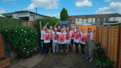 Group of volunteers from B&Q cheering in the finished garden.