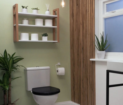A small green bathroom with thin vertical wooden panelling on the right side of the wall.