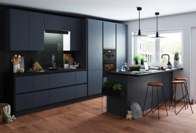 Open plan kitchen with black cabinets, dark wooden flooring, with a breakfast bar and black and wooden bar stools.