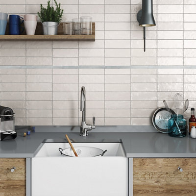 Grey flat glass border tile on a kitchen wall, with a smooth glass finish.