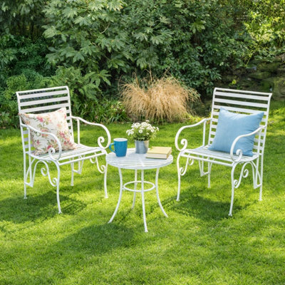 Melody Maison Ornate Metal White Round Garden Table & Set Of 2 Ornate Garden Chairs from B&Q