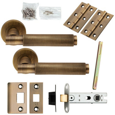 Door Handle & Latch Pack Antique Brass Knurled Round Bar Screwless Round Rose from B&Q