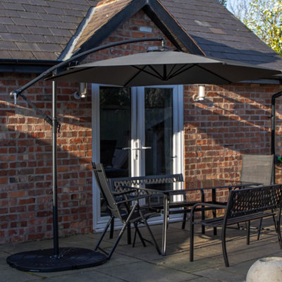 Samuel Alexander Outdoor 6 Person Rectangular Glass Top Garden Dining Table Benches & Chairs With Grey Banana Parasol And Base from B&Q