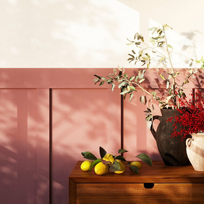 Wall panels on the lower half of a wall painted in warm coral pink, the upper half of the wall is painted in white.