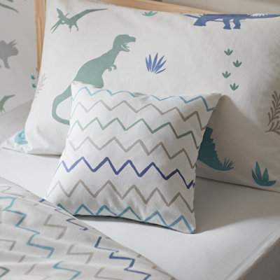 A children's bed with dinosaur and zig zag print bedding. 