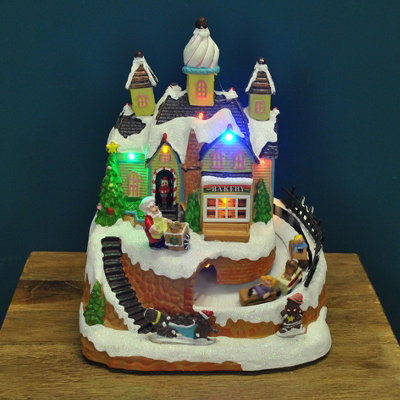 Selections Christmas Village Bakery Scene Ornament With Lights Moving Children's Train And Sound from B&Q