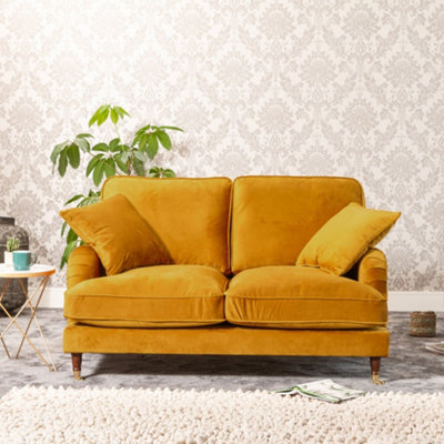 Mackenzie 150Cm Wide Mustard Yellow 2 Seat Velvet Fabric Sofa With Brass Coloured Wheel Tipped Walnut Coloured Wooden Legs from B&Q