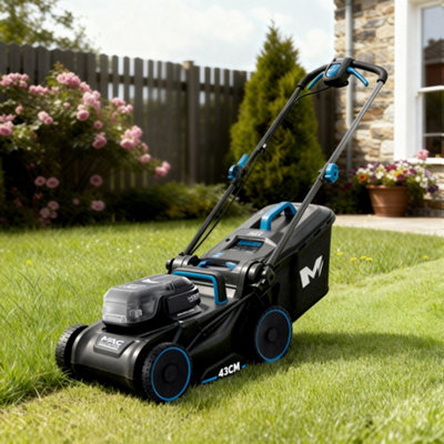 Mowing a lawn with a garden lawnmower in spring