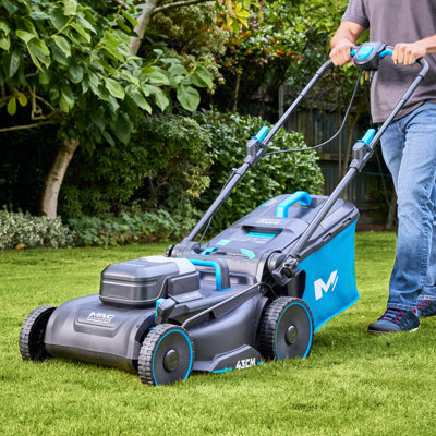 Mowing a green garden lawn with a lawnmower