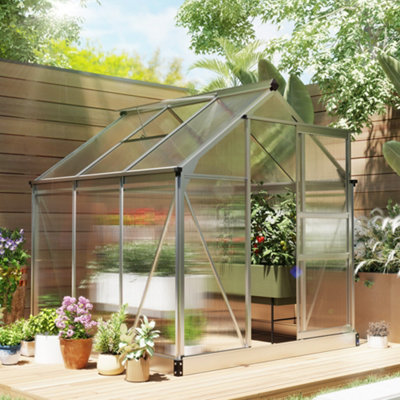 Glass greenhouse in a garden used for growing plants and vegetables