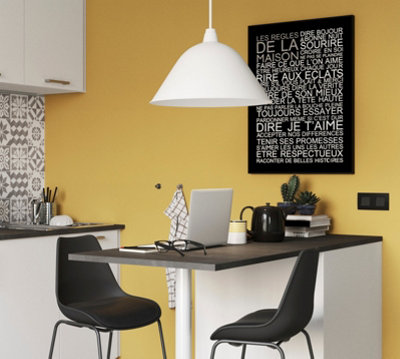 Oversized white pendant light hanging in a small yellow kitchen, creating a bold statement.
