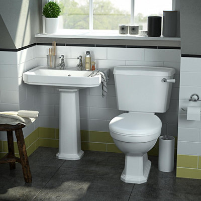 Traditional style low level toilet with a cistern fastened to the wall behind the toilet.