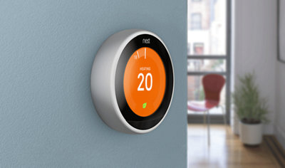 Close-up of a Nest smart thermostat on a wall.