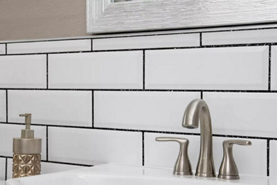 Black tile grout on white bathroom metro tiles.