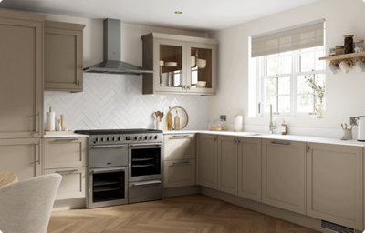 Earthy, warm grey cabinets create a cosy and inviting space. Sleek chrome handles and herringbone splashback add modern elegance. Glass-fronted cupboards offer both practical and stylish storage options.