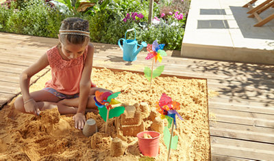 A sandpit built into garden decking, offering a fun and playful feature for children.