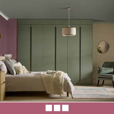 A modern fitted wardrobe with integrated handles and a soft green finish.