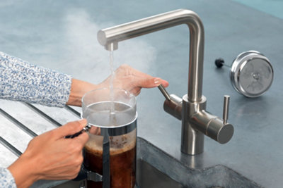 Person holding a cafetiere underneath a InSinkErator 3N1 Stainless steel hot and cold water tap, which is dispensing hot water.