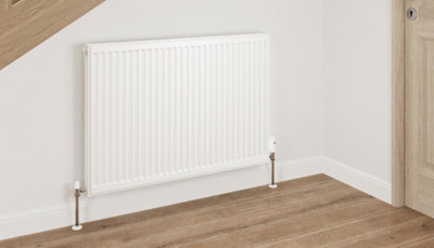 White single panel radiator with white and chrome angled radiator valves.