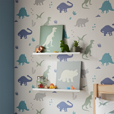 A children's bedroom wall decorated with dinosaur print wallpaper, dinosaur wall art, and a selection of toys.