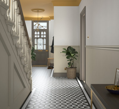 A hallway with white and beige walls and black and white floor, with stairs, a potted plant, a grey door, a yellow ceiling, a bench, and a pendant lamp.