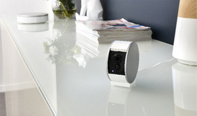 Home security system buying guide with a camera in a home setting.
