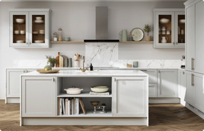 A light grey shaker-style kitchen in an L-shape and kitchen island. Both the kitchen units and the island have a white and grey marble-effect countertop, and this extends to form a splashback.