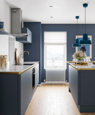 Blue galley kitchen with blue cabinetry, blue walls and light wooden flooring.