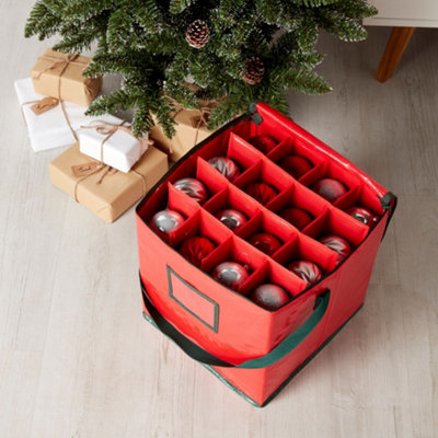Red decoration storage bag full of baubles next to a christmas tree