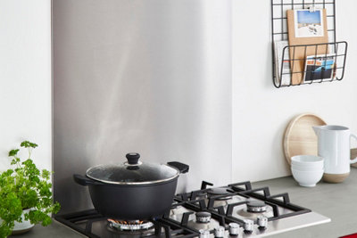 A stainless steel kitchen splashback panel behind the oven.