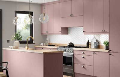 The Ethos kitchen, featuring sleek soft pink cabinets, chrome fixtures and cupboard handles, and light wood countertops.