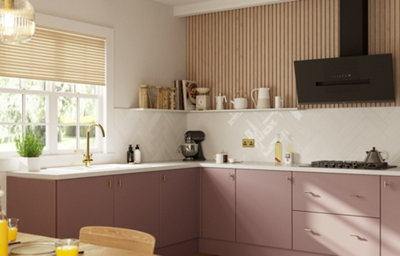 The Ethos kitchen, featuring sleek soft pink cabinets, chrome fixtures and cupboard handles, and white marble countertops.