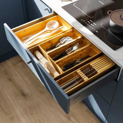 Close up shot of a open kitchen drawer with a wooden cutlery tray.