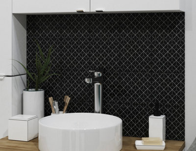 Bold black and white geometric splashback behind a white basin.