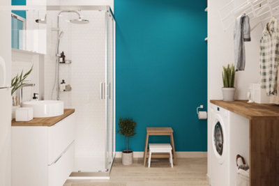 A white bathroom with a bold teal feature wall, adding colour and depth to the space.